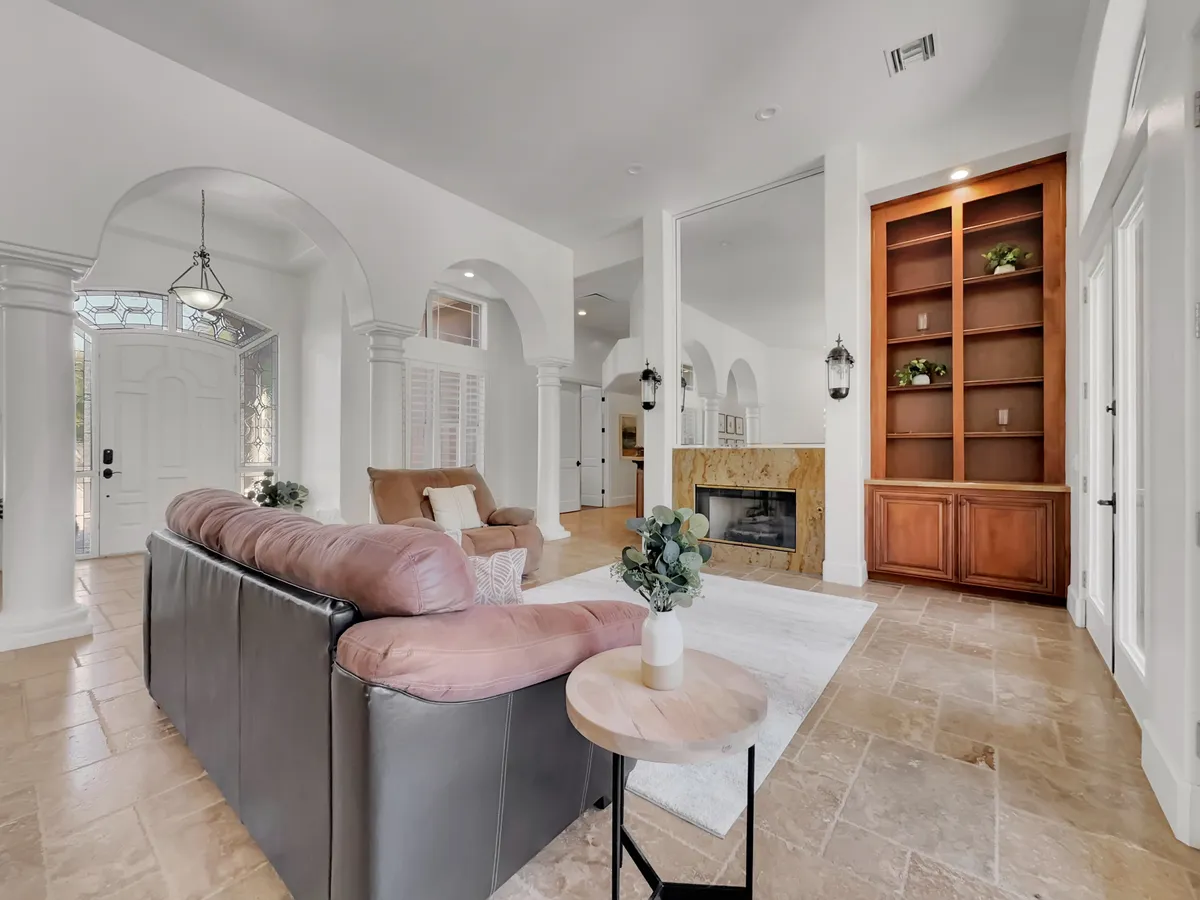 A cozy living room setting with a plush sofa, a warm fireplace, and built-in shelves. The space exudes comfort and is ideal for relaxing, entertaining guests, or gathering around for a board game night.