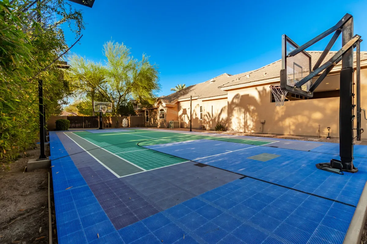 A dedicated basketball court surrounded by trees provides a vibrant backdrop for friendly games and family competitions. The area is spacious, encouraging active engagement and teamwork.